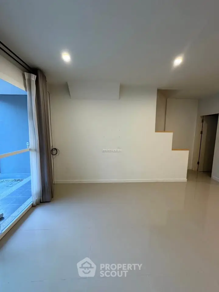 Spacious modern living room with large windows and sleek flooring