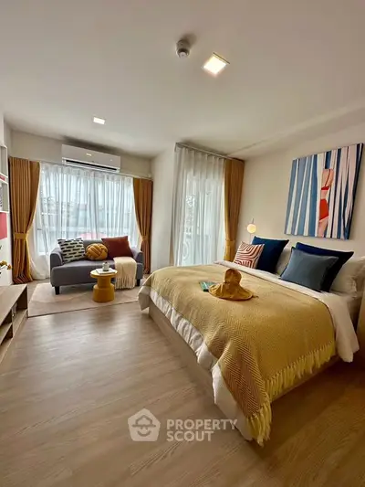 Spacious bedroom with cozy seating area and modern decor