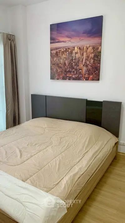 Modern bedroom with cityscape artwork and cozy bedding