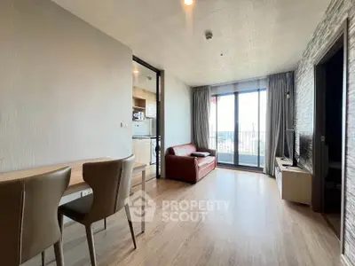 Modern living room with balcony view and open kitchen layout in stylish apartment.