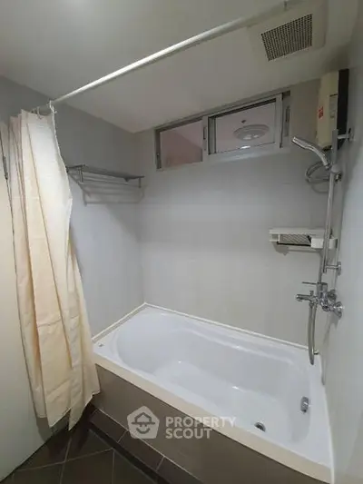 Modern bathroom with bathtub and shower in a sleek, minimalist design.