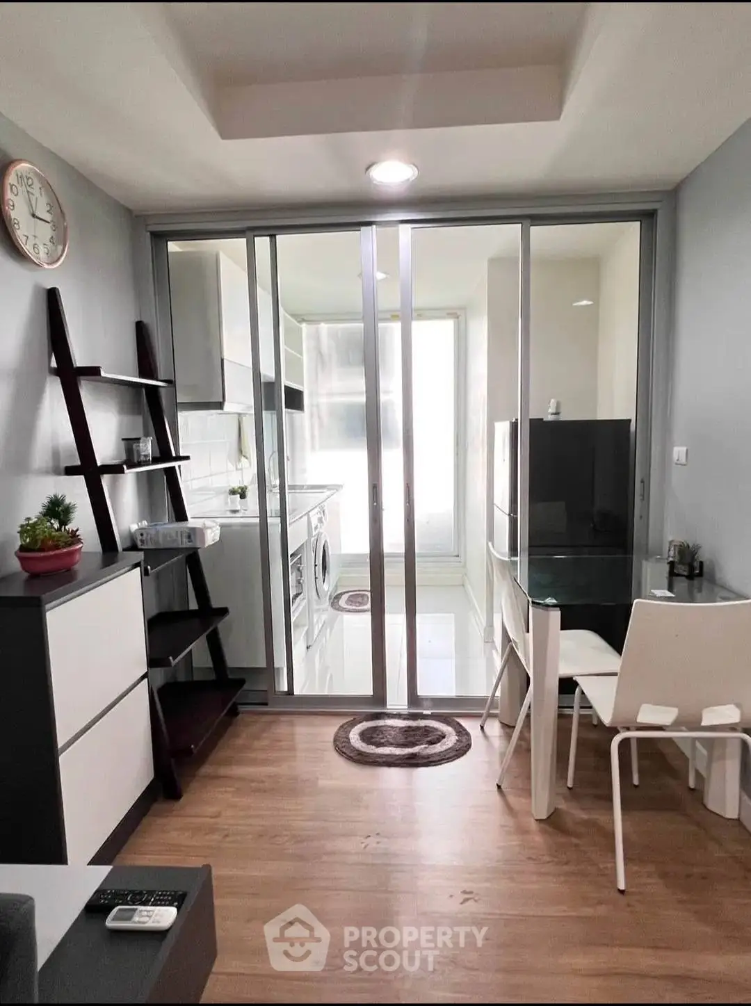 Modern compact apartment with glass partition, dining area, and laundry facilities.