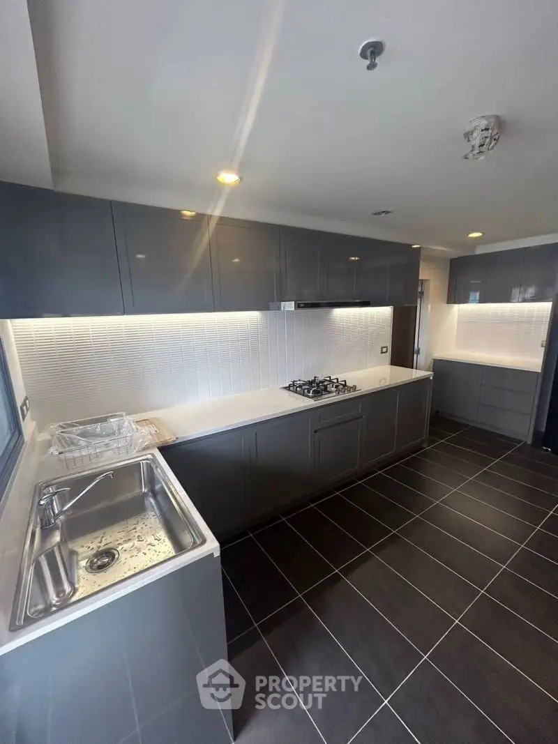 Modern kitchen with sleek cabinetry and gas stove in contemporary apartment