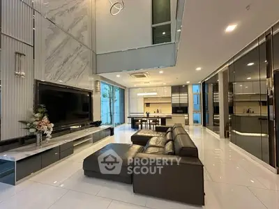 Luxurious modern living room with high ceilings, sleek furniture, and elegant decor in a spacious open layout.