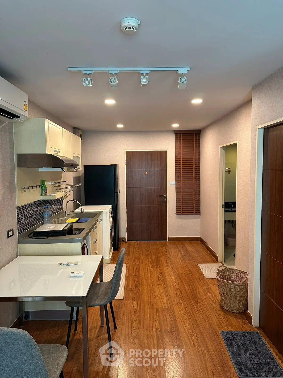 Modern kitchen with wooden flooring and sleek appliances in a cozy apartment.