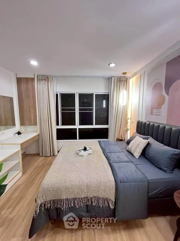 Luxurious bedroom with modern decor and large window offering city views, perfect for urban living.