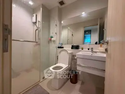 Modern bathroom with glass shower and sleek fixtures in a contemporary apartment.