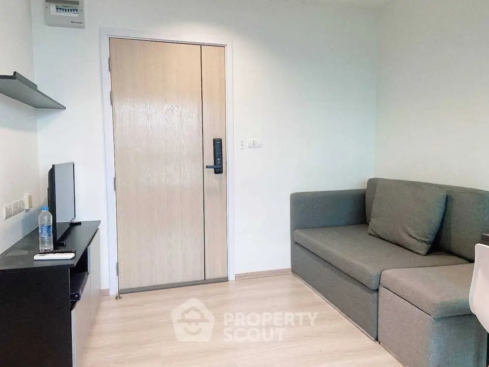 Cozy living room with modern sofa and TV setup, perfect for relaxation.