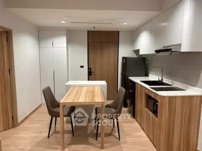 Modern kitchen with sleek design and dining area, featuring wooden accents and contemporary furniture.