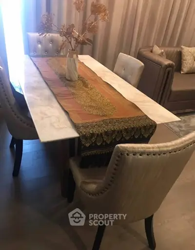Elegant dining area with marble table and plush chairs in a stylish living room setting.
