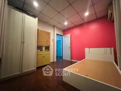 Spacious bedroom with vibrant pink accent wall and modern furnishings