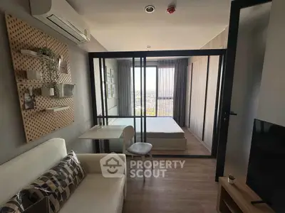 Modern studio apartment with glass partition, cozy living area, and city view.