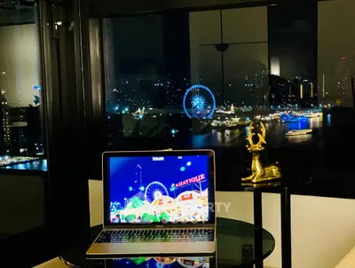 Stunning city view from modern apartment with laptop and decorative deer statue.