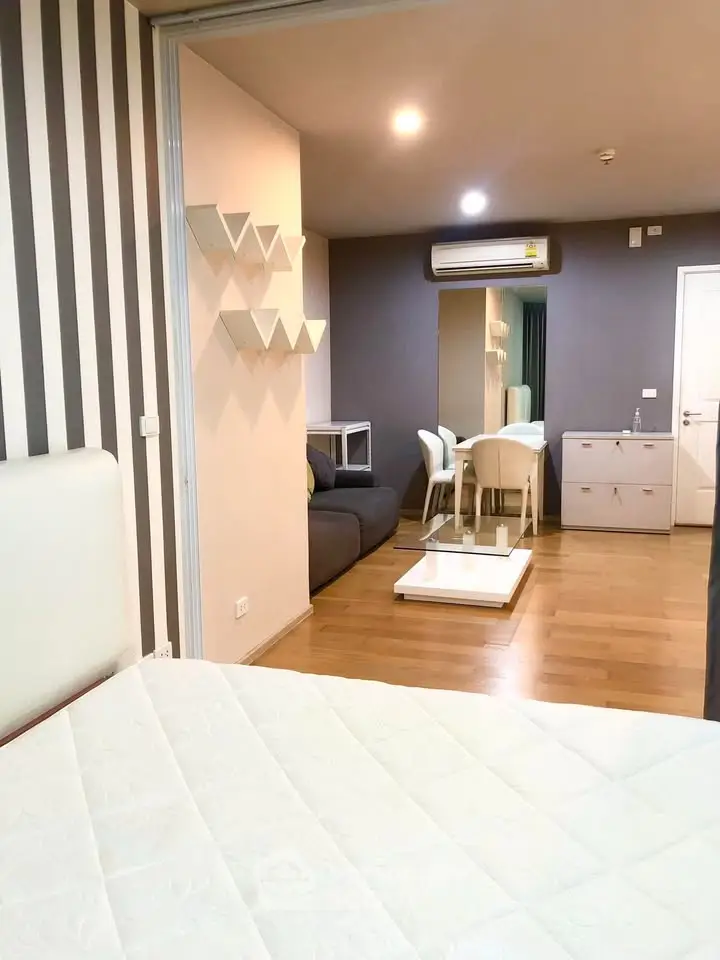 Modern studio apartment with stylish decor and open layout, featuring a cozy living area and dining space.