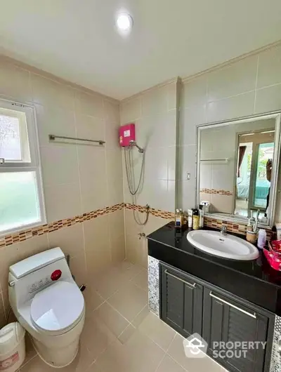 Modern bathroom with sleek fixtures and stylish vanity in a bright, tiled space.