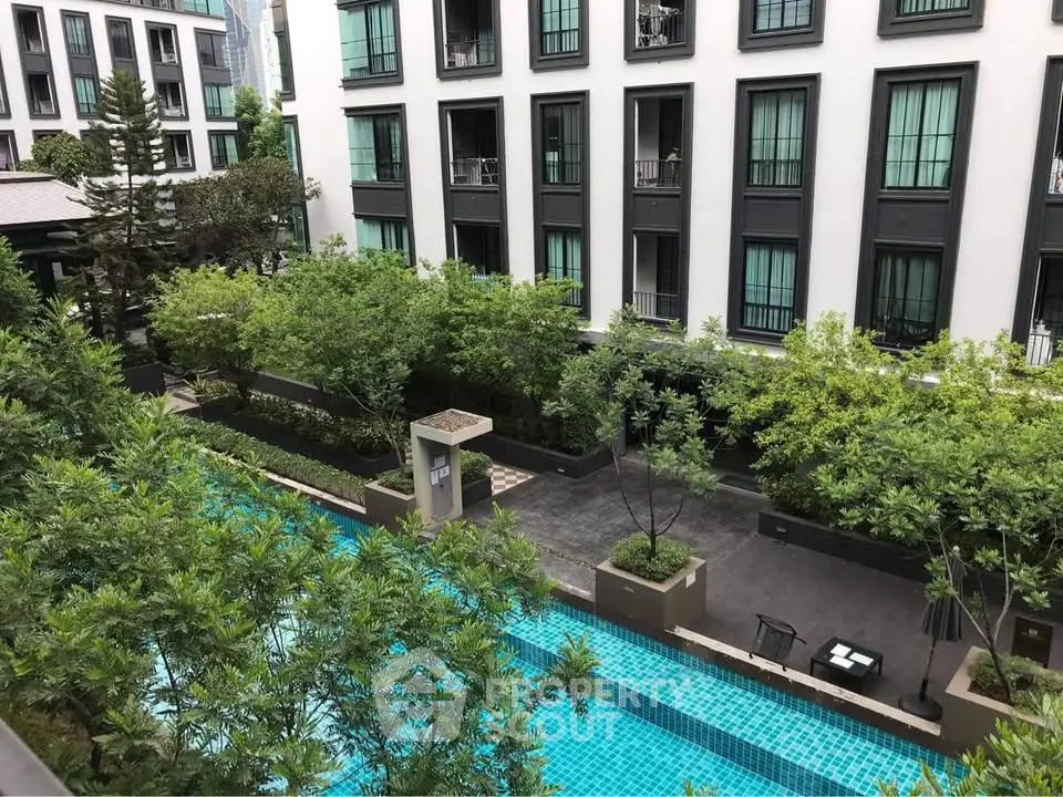 Modern apartment building with lush greenery and a sparkling pool view.