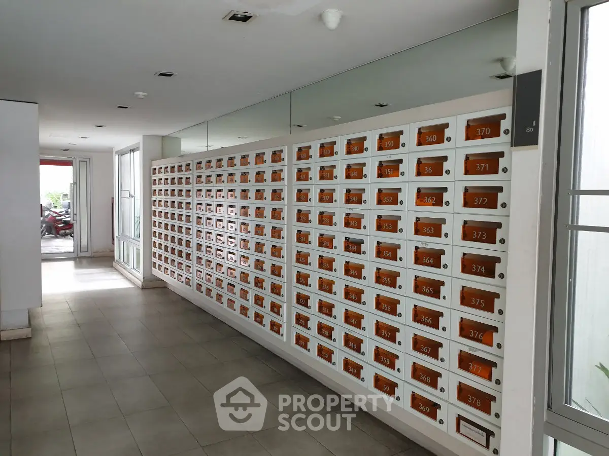 Modern apartment building mailboxes in a sleek hallway with tiled flooring.