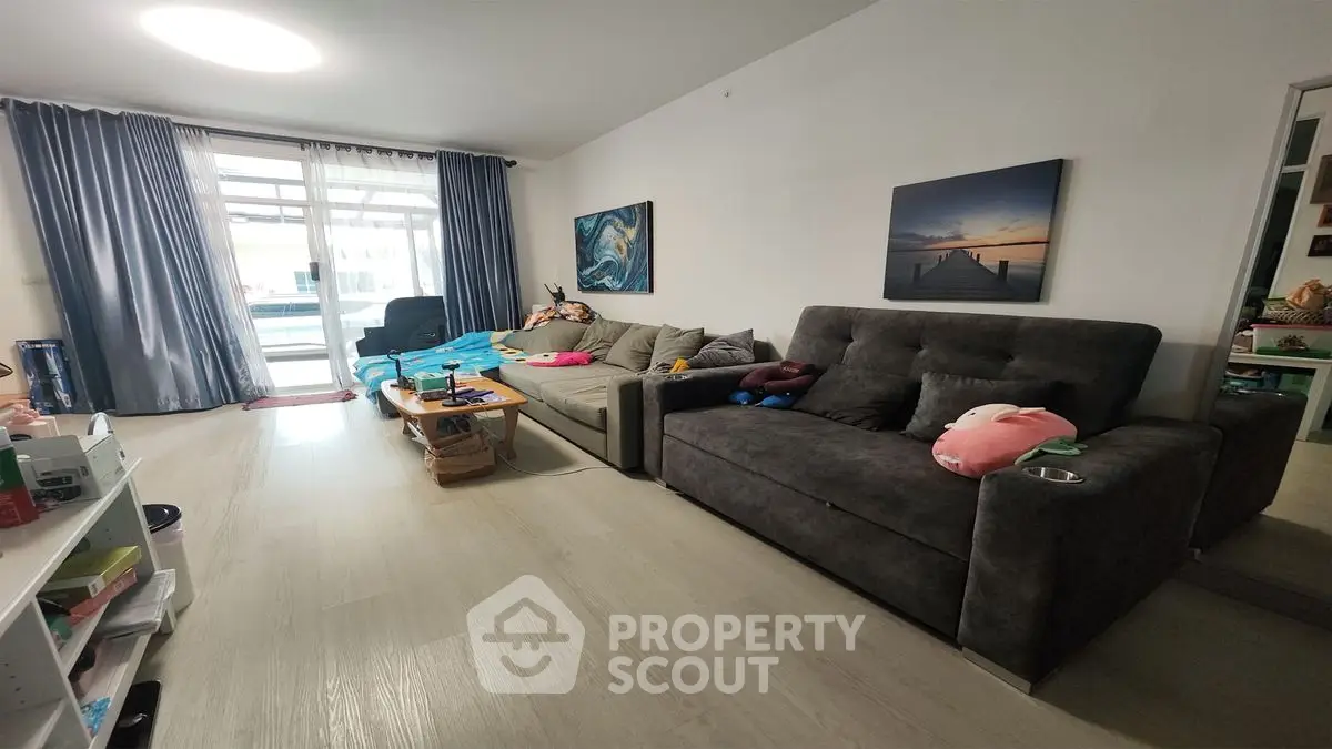 Spacious living room with modern decor and large windows for natural light.