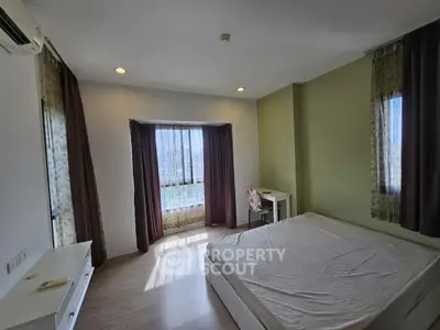 Spacious bedroom with large windows and natural light