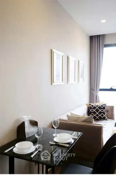 Modern living room with elegant decor and natural light, featuring a cozy sofa and dining setup.