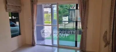 Spacious room with sliding glass doors leading to a lush garden view, perfect for natural light and outdoor access.