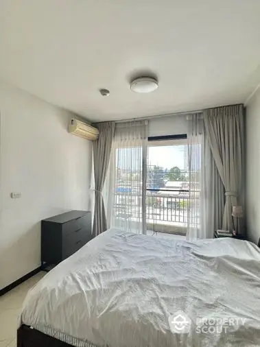 Bright and airy bedroom with large window offering ample natural light, complete with cozy bedding and modern furnishings for a comfortable living experience.