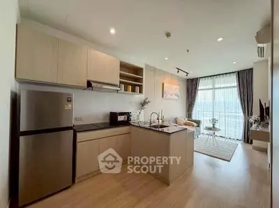 Modern open-layout kitchen and living room with natural light and stylish decor.