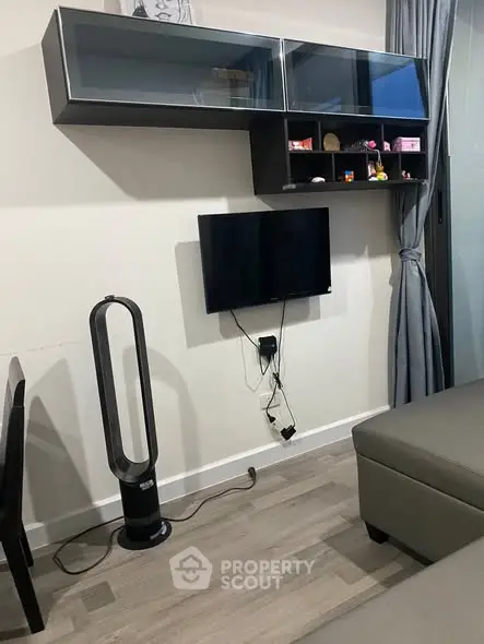 Modern living room with sleek wall-mounted TV and stylish shelving unit.