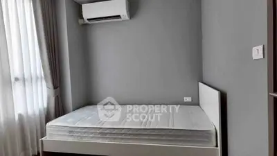 Modern bedroom with minimalist design featuring a comfortable bed and air conditioning.