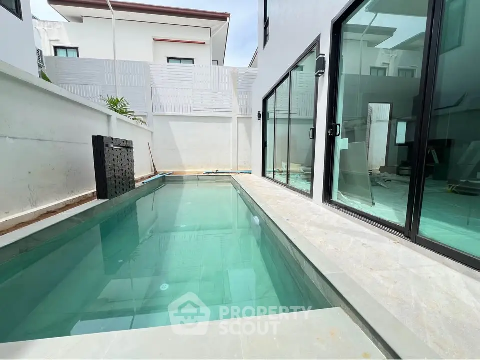Modern residential property with sleek private pool and glass sliding doors.