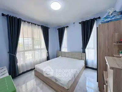 Spacious bedroom with large windows and modern furnishings