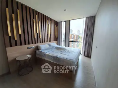Modern bedroom with stylish wooden accent wall and large window offering city view.
