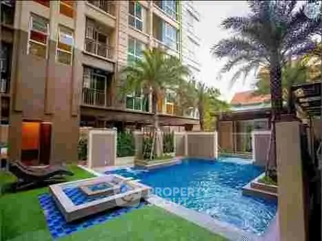 Luxurious apartment complex with a stunning pool and lush palm trees, perfect for relaxation.