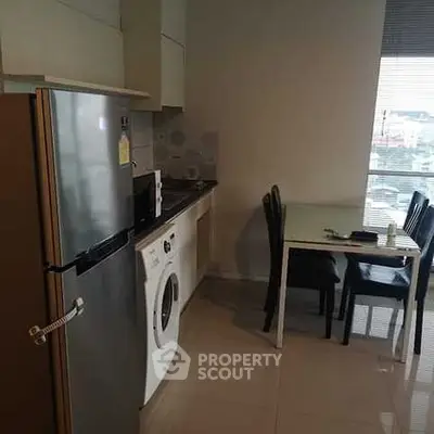 Modern kitchen with sleek appliances and dining area in a cozy apartment setting.