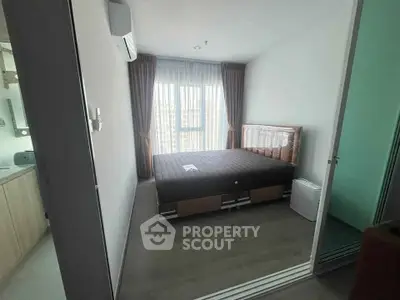 Modern bedroom with large window and minimalist design in a high-rise apartment.