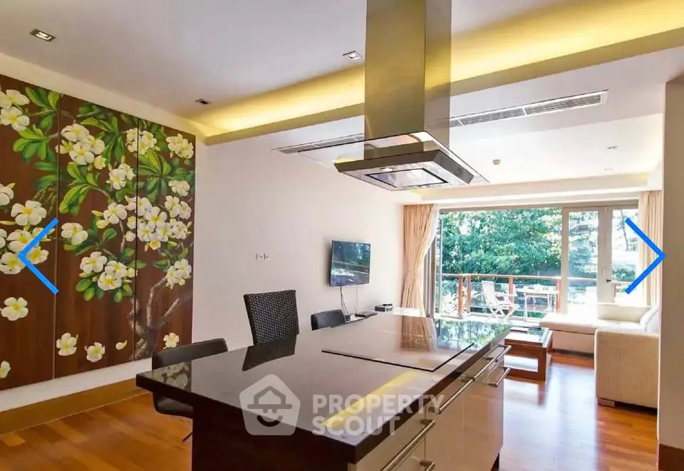 Luxurious open-plan living room with modern kitchen and large balcony view.