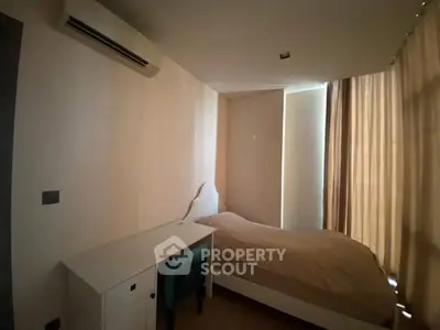 Cozy bedroom with natural light and modern air conditioning unit.