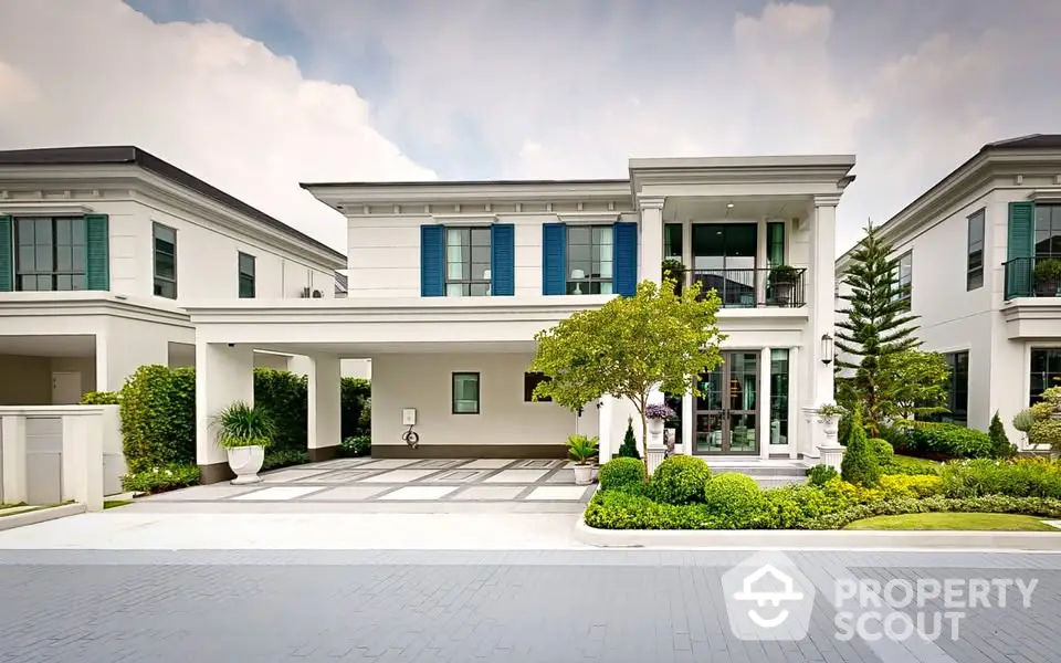 Luxurious modern villa with elegant facade and lush landscaping in upscale neighborhood.