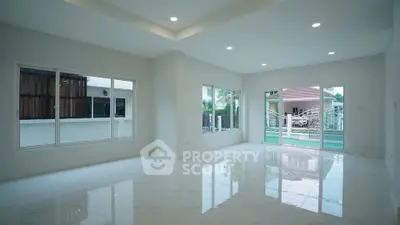 Spacious modern living room with large windows and glossy floors