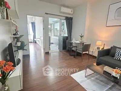 Modern living room with stylish decor and open layout, featuring hardwood floors and cozy seating area.