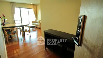 Modern apartment interior with open living and dining area, featuring wooden floors and natural light.