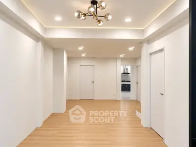 Spacious modern living room with elegant lighting and open kitchen view