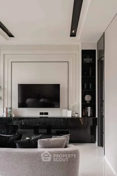 Luxurious modern living room with sleek black marble accents and wall-mounted TV.