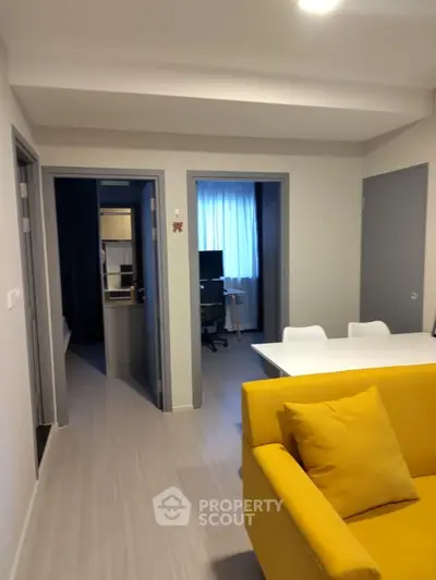 Modern apartment interior with vibrant yellow sofa and open layout