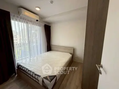Modern bedroom with large window and air conditioning in urban apartment