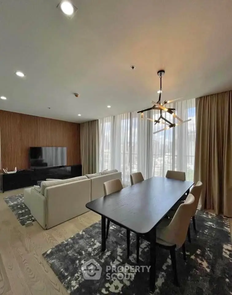 Luxurious modern living room with elegant dining area and large windows offering natural light.