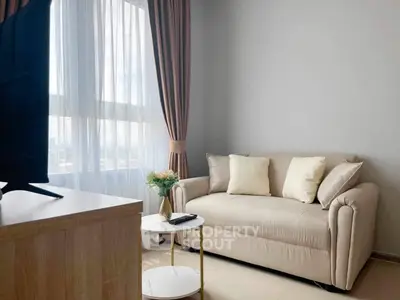 Cozy living room with beige sofa and elegant curtains, perfect for relaxation.