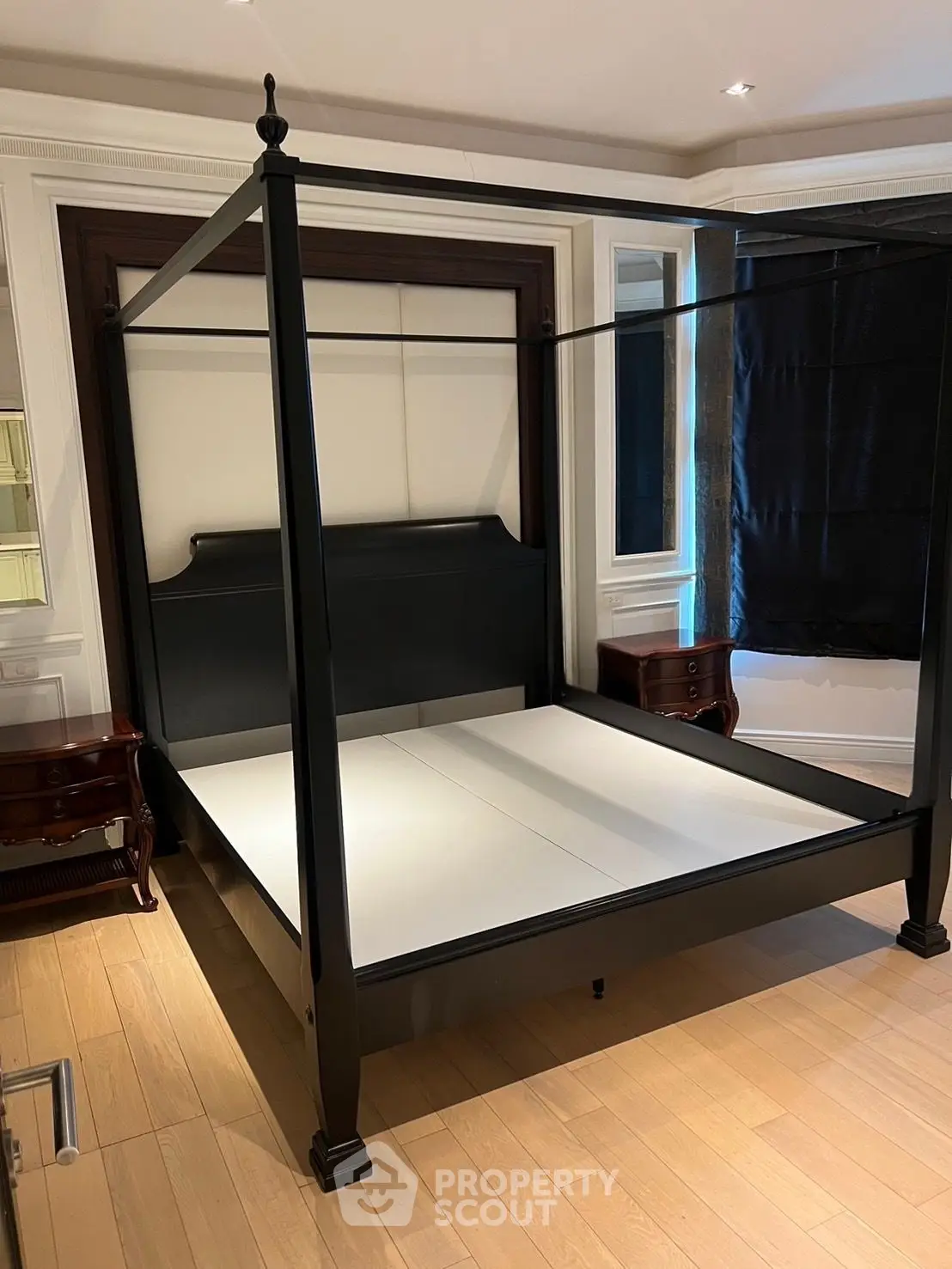 Elegant bedroom with a stylish four-poster bed and wooden flooring