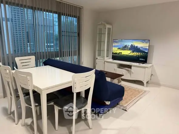 Modern living room with dining area, featuring sleek furniture and large windows with city view.