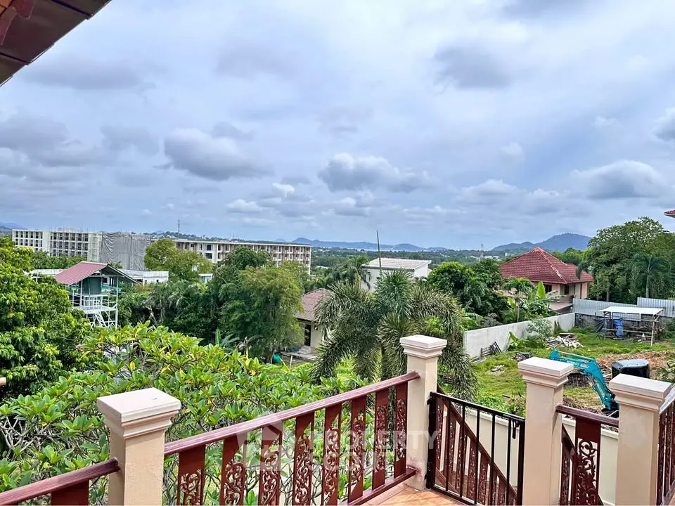 Scenic balcony view overlooking lush greenery and distant mountains, perfect for tranquil living.